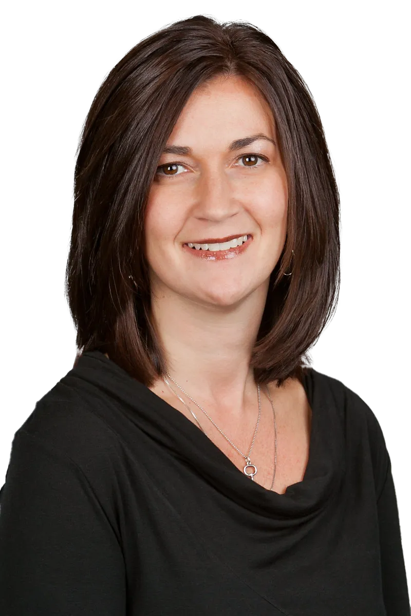 Smiling woman in a black top with layered necklace, shoulder-length brown hair, facing forward.