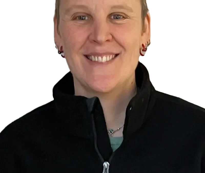 Portrait of a smiling person in an Agility Orthopedics jacket on a white background.