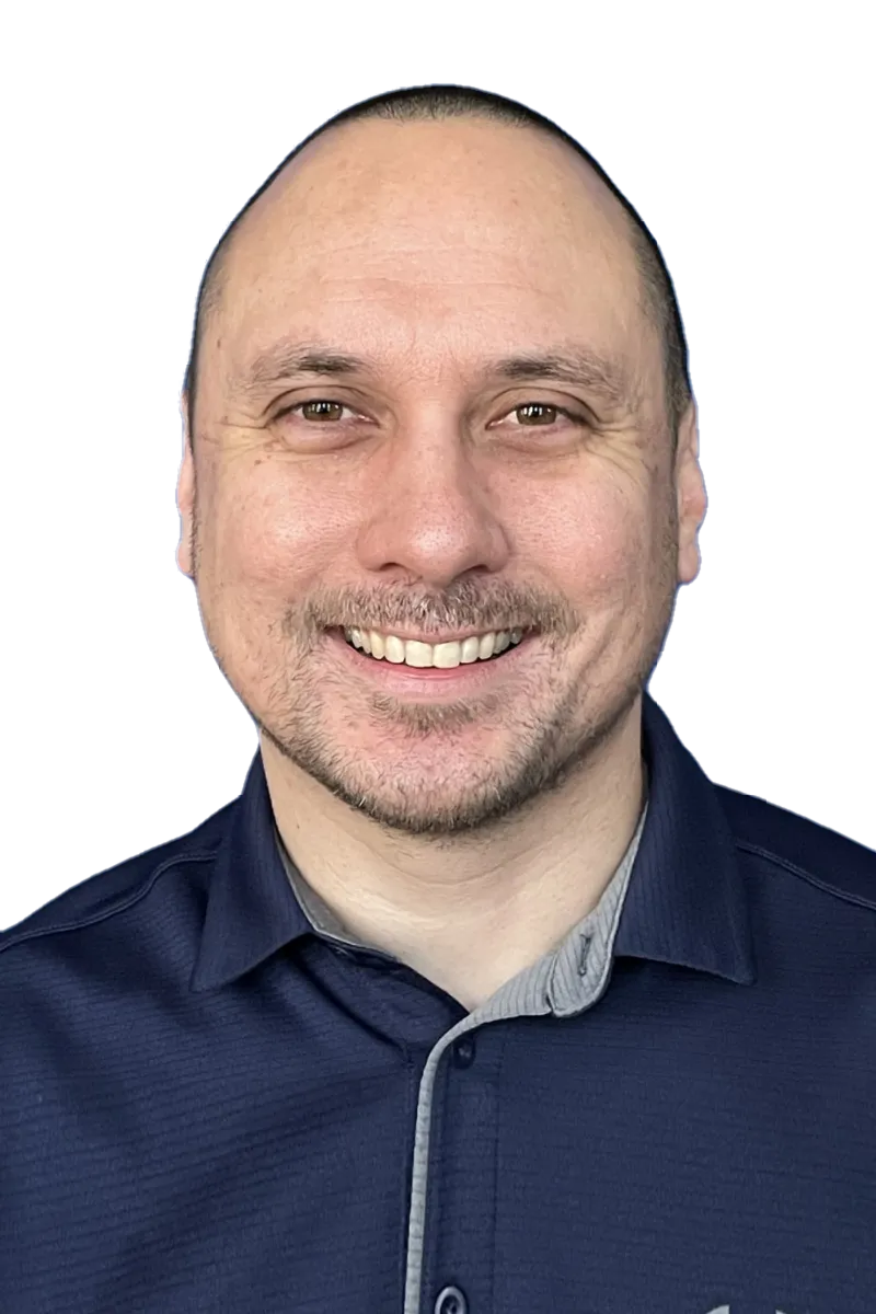 Man smiling in a navy blue shirt against a plain background.